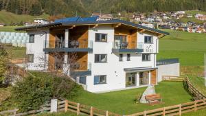 una casa en la cima de una colina con una valla en Apartments am Bichl, en Fulpmes