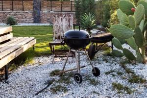 a bbq grill in a garden with a bench at Alley Tiny House in Fethiye