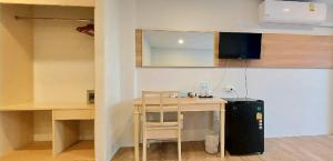 卡隆沙灘的住宿－Karon Living Room - SHA Plus，厨房配有桌子和带冰箱的书桌