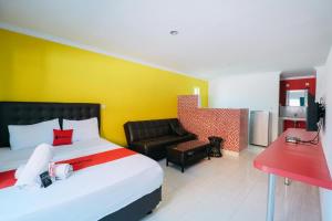 a hotel room with a bed and a couch at RedDoorz at Kawaii Apartment Jimbaran in Balian