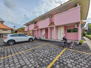 un coche aparcado en un aparcamiento frente a un edificio en RedDoorz at Kawaii Apartment Jimbaran en Balian