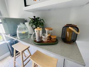 a kitchen counter with a tray with jars and stools at Esme Road - WE HAVE NO LOADSHEDDING! in Cape Town