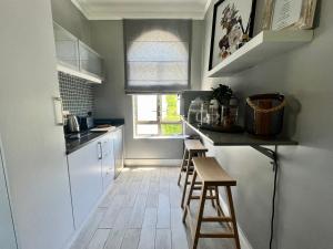 a small kitchen with a counter and stools in it at Esme Road - WE HAVE NO LOADSHEDDING! in Cape Town