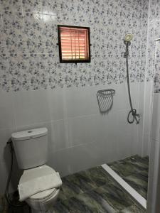 a bathroom with a toilet and a window at Traditional Thai house บ้านเรือนไทย ใกล้หาดระยอง in Ban Chak Phai +10 photos