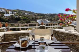 a table with a cup of coffee on a balcony at Rita Rooms Sifnos in Platis Gialos