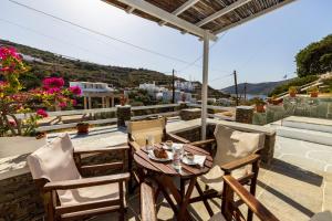 a table and chairs on a balcony with a view at Rita Rooms Sifnos in Platis Gialos