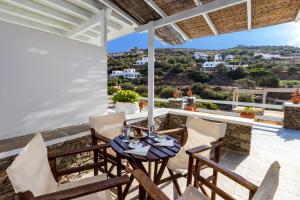 a patio with a table and chairs on a roof at Rita Rooms Sifnos in Platis Gialos