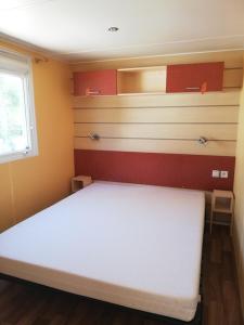 een slaapkamer met een groot wit bed in een kamer bij Hébergements sur camping au bord de la mer in Crozon