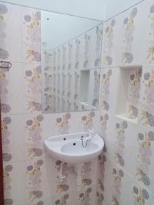 ein Badezimmer mit einem weißen Waschbecken und einem Spiegel in der Unterkunft Homestay Premium 45 in Jepara