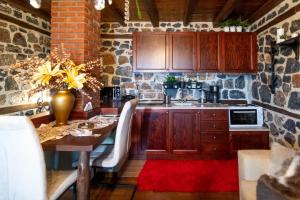 a kitchen with a table with chairs and a stone wall at Palaios Agios Athanasios Luxury Μaisonette in Palaios Agios Athanasios