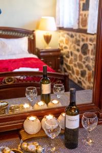 dos botellas de vino y copas en una mesa frente a un espejo en Palaios Agios Athanasios Luxury Μaisonette en Palaios Agios Athanasios