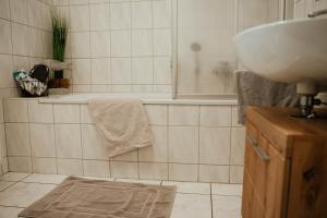 a bathroom with a sink and a bath tub and a sink at Ferienwohnung Katharinenberg in Katharinenberg +13 photos