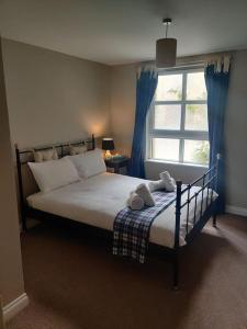 1 dormitorio con 1 cama con cortinas azules y ventana en Next to the Palace and Royal Mile with parking, en Edimburgo