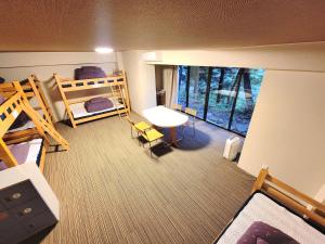 K's House Nikko - Kinugawa Onsen Hostel في نيكو: إطلالة علوية لغرفة نوم مع أسرة بطابقين