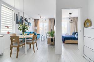 kuchnia i jadalnia ze stołem oraz sypialnia w obiekcie Mi Casa Holidays Apartamenty Olimpijska O2 w mieście Mielno