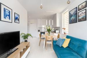 salon z niebieską kanapą i stołem w obiekcie Mi Casa Holidays Apartamenty Olimpijska O2 w mieście Mielno