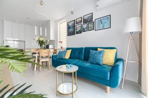 salon z niebieską kanapą i stołem w obiekcie Mi Casa Holidays Apartamenty Olimpijska O2 w mieście Mielno