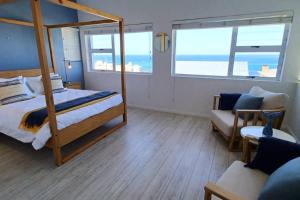Seegeluk, magnificent beach house in De Kelders في دو كيلدرز: غرفة نوم مع سرير بطابقين وأريكة
