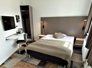 a hotel room with a bed and a desk and a table at Hotel Skivehus in Skive