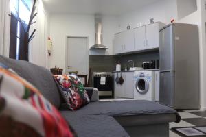 uma sala de estar com um sofá e uma máquina de lavar roupa em Santa Luzia Center na Ribeira Grande