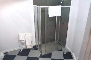 a shower stall in a bathroom with a checkered floor at Santa Luzia Center in Ribeira Grande +10 photos