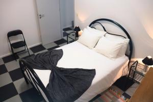 1 dormitorio con 1 cama y suelo blanco y negro en Santa Luzia Center en Ribeira Grande