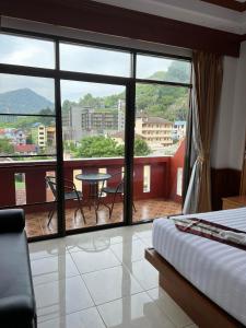 a bedroom with a view of a balcony with a table at Vice City guest house in Patong Beach