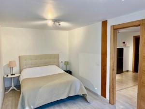 a white bedroom with a bed and a table at APARTAMENTOS RURALES El Llagar de Cue in Llanes