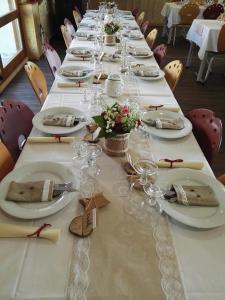 uma mesa longa com pratos brancos e flores em Le Relais Nordique em Giron