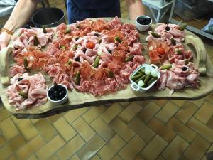 Giron的住宿－勒瑞萊斯諾迪克賓館，一张桌子上带肉和蔬菜的大比萨饼
