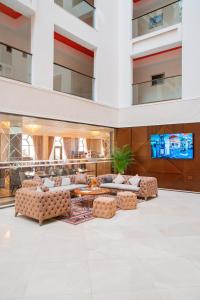 a lobby with couches and a tv in a building at Arion Hotel Baku in Baku