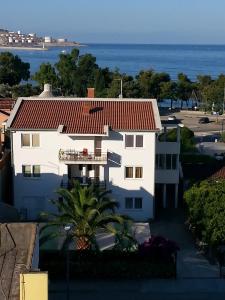 a white house with a red roof and the ocean at Apartments Stevo Nikočević in Bar