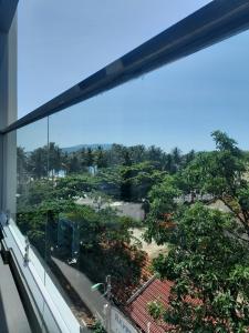 uma vista para um jardim a partir de uma janela de um edifício em Happy Home em Nha Trang