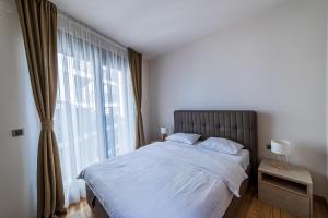 a bedroom with a bed and a large window at Elite apartments Podgorica in Podgorica
