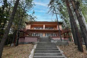 una casa en el bosque con escaleras que conducen a ella en Park Resort Aghveran, en Agveran