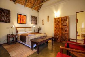 a bedroom with a bed and a table in a room at Rosedale Organic Farm Bed & Breakfast in Addo