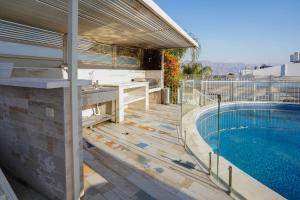 a house with a swimming pool next to a building at Yalarent Enorma complex with shared heated pool in Eilat