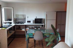 a kitchen with a table and chairs in a kitchen at Chalet les Azalées in Le Tampon