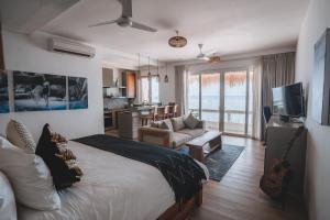 a bedroom with a bed and a living room at Legends Beachfront Resort in Uluwatu