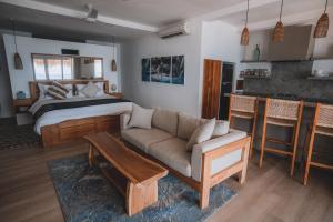 Legends Beachfront Resort في أُلُواتو: غرفة معيشة مع سرير وأريكة