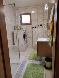 a bathroom with a shower and a washing machine at Studio Stefan in Umhausen