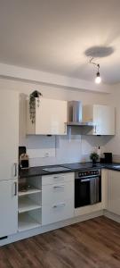 a kitchen with white cabinets and a black counter top at Apartment am Weinberg Kleinaspach in Aspach