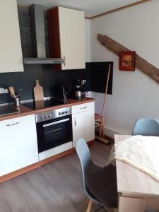 a kitchen with white cabinets and a stove top oven at Ferienhaus Fiete in Plau am See