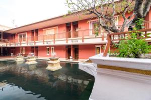 a building with a pond in front of a building at Ruen Rattana Resort in Nonthaburi