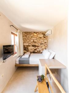 a bedroom with a bed and a stone wall at Hamezi Instyle Suite 2 Traditional Sunny Cretan Houses in Khamézion