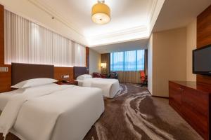 ein Hotelzimmer mit 2 Betten und einem Flachbild-TV in der Unterkunft Crowne Plaza Foshan, an IHG Hotel - Exclusive bus stations for HKSAR round-trips in Foshan