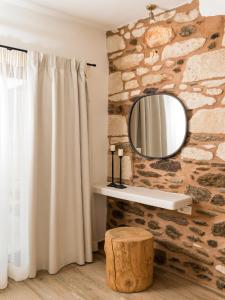 a bathroom with a stone wall and a mirror at Hamezi Instyle Suite 2 Traditional Sunny Cretan Houses in Khamézion