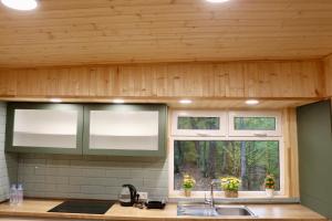 cocina con techos de madera, lavabo y ventana en Shavit Village Glamping, en Akhatani 40 fotos más