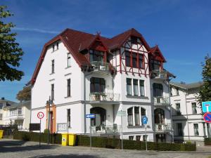 a white building with a red roof at Ledwig, Villa Medici in Ahlbeck