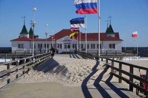 a building on a pier with flags on it at Ledwig, Villa Medici in Ahlbeck